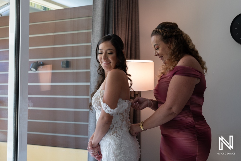 Bride prepares for her wedding in a beautiful suite at Avila Beach Hotel, Curacao, as a loved one helps with her dress