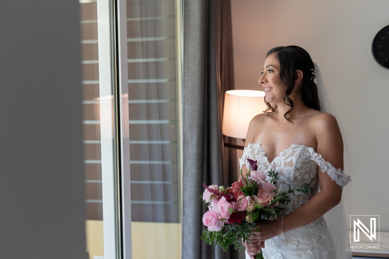 Beautiful bride with bouquet prepares for wedding ceremony at Avila Beach Hotel in Curacao, creating a memorable moment of anticipation