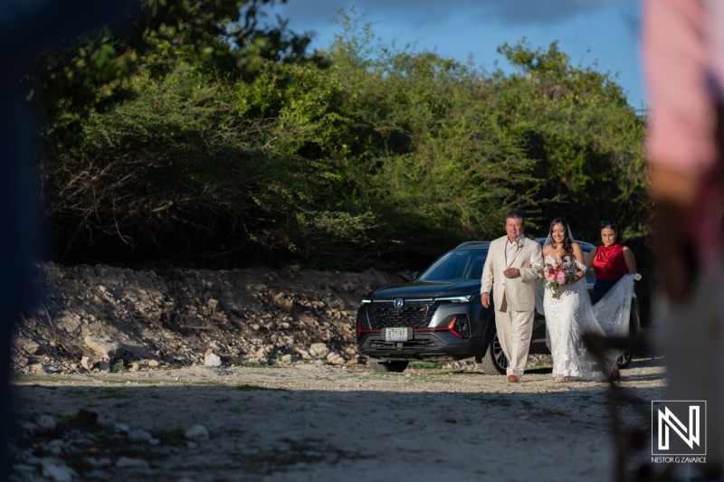 Beautiful wedding ceremony at Playa Hunku in Curacao with bride walking along the beach accompanied by her father