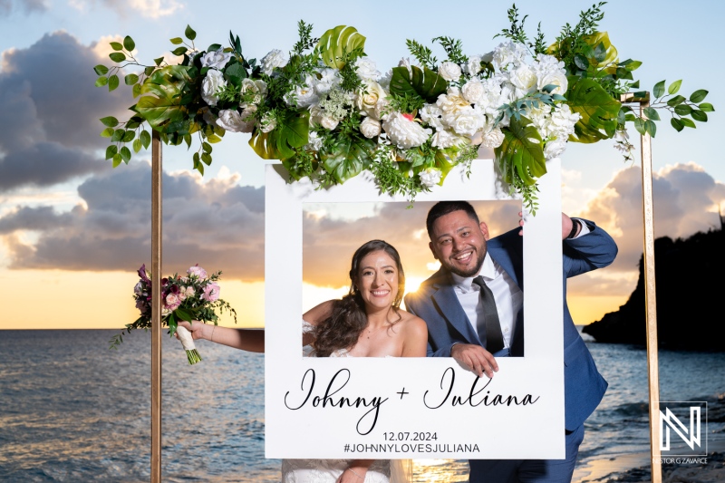 Couple joyfully celebrates their wedding at Playa Hunku in Curacao during sunset on December 7, 2024, capturing love and happiness in a decorative frame