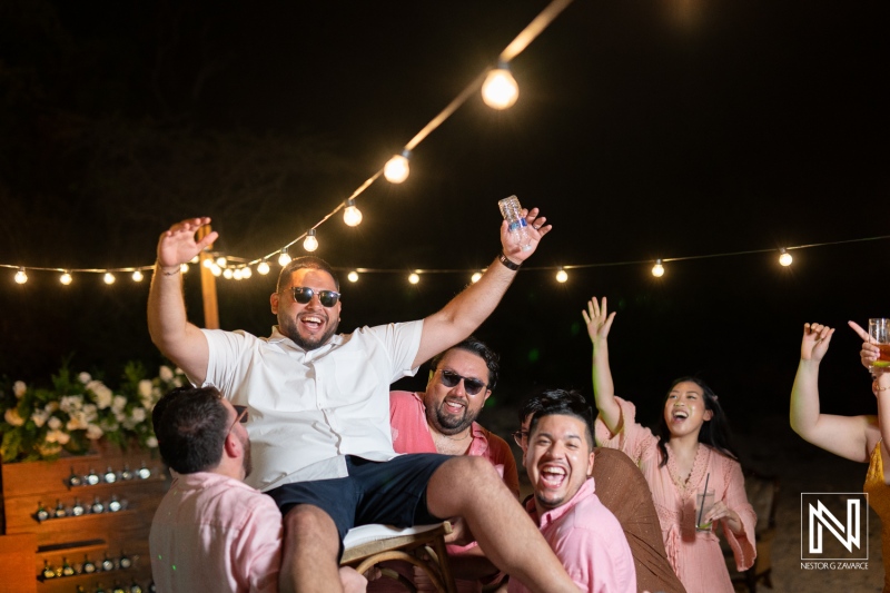 Celebration of love at a Curacao wedding on Playa Hunku with joyful guests enjoying the night