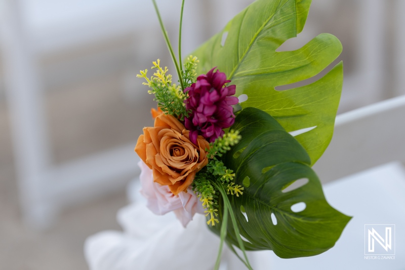 Brightly Colored Floral Arrangement Featuring Tropical Leaves, Roses, and Decorative Accents in a Serene Outdoor Setting During Daytime