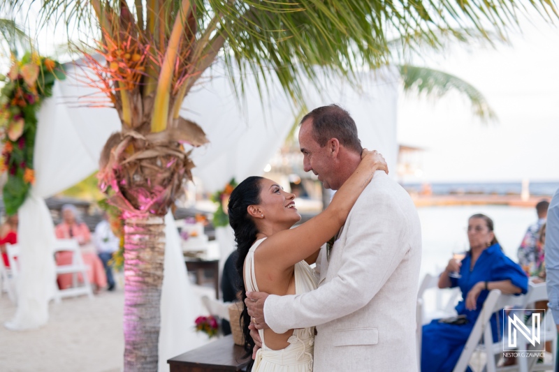 A Couple Shares a Heartfelt Dance Under the Palm Trees During Their Beachfront Wedding Ceremony at Sunset in a Tropical Paradise