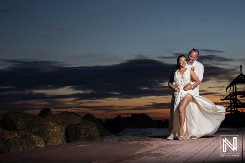 Elegant Couple Celebrating Their Wedding at Sunset by the Beach, Capturing a Romantic Moment With a Scenic Backdrop of Clouds and the Horizon