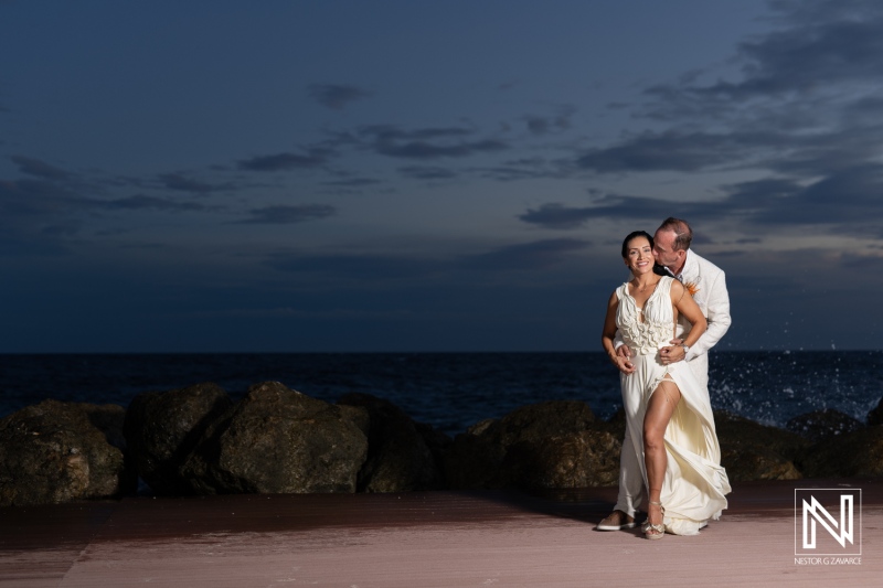 A Couple Shares a Romantic Dance by the Ocean During Sunset, Surrounded by Tranquil Waves and a Softly Lit Sky in a Coastal Paradise