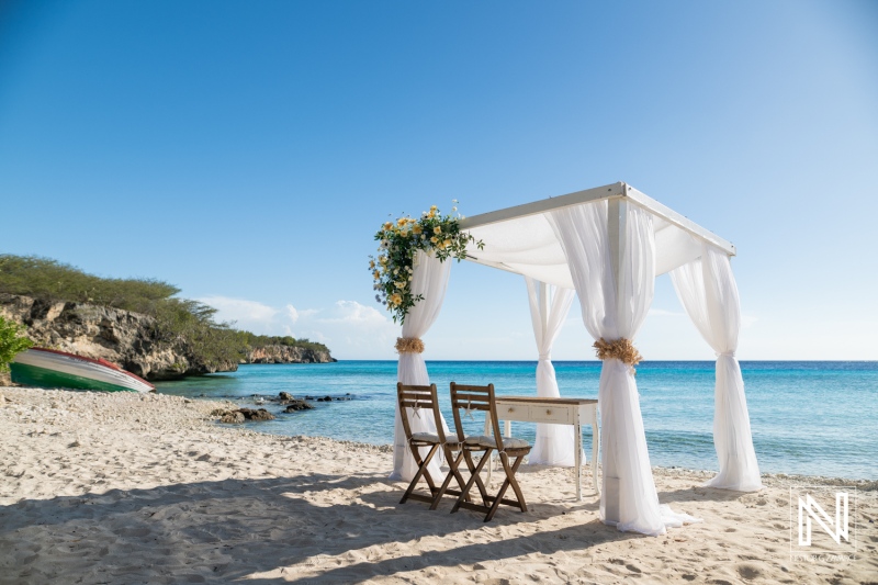 Wedding setup at Playa Porto Mari in Curacao with ocean backdrop and white draped canopy