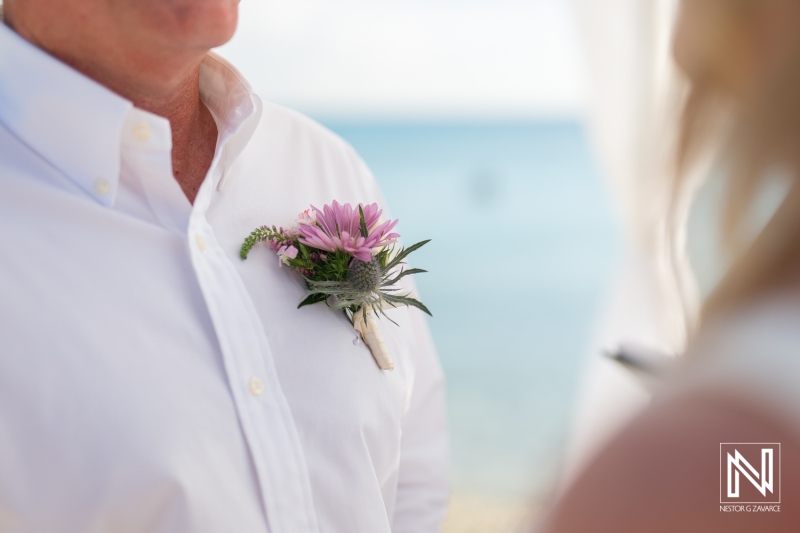 Flower boutonniere adorns groom at beautiful wedding ceremony on Playa Porto Mari in Curacao during sunny afternoon