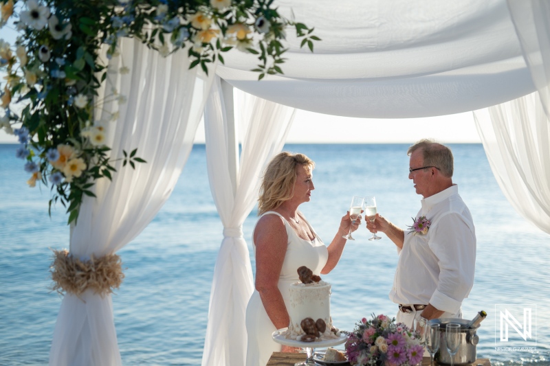 Wedding celebration at Playa Porto Mari, Curacao with a toast over a beautiful beachfront setup