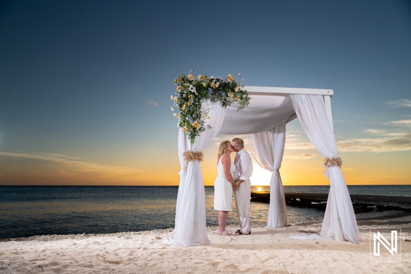 Couple exchanging vows at sunset during a romantic wedding ceremony on the beautiful shores of Playa Porto Mari in Curacao