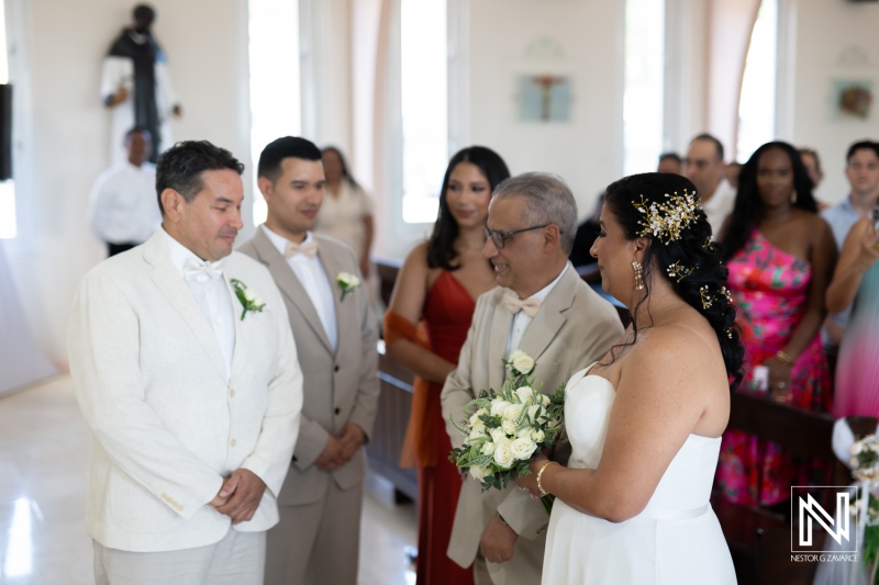 Wedding celebration in Curacao featuring joyful couple exchanging vows in a beautiful chapel setting surrounded by loved ones