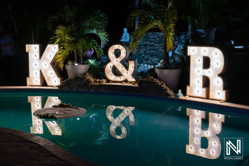 Illuminated letters K and R by the poolside during a romantic wedding celebration in Curacao at night
