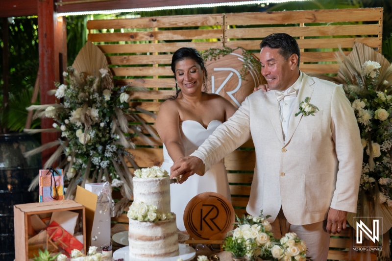 Couple shares a joyful moment as they cut their wedding cake in Curacao