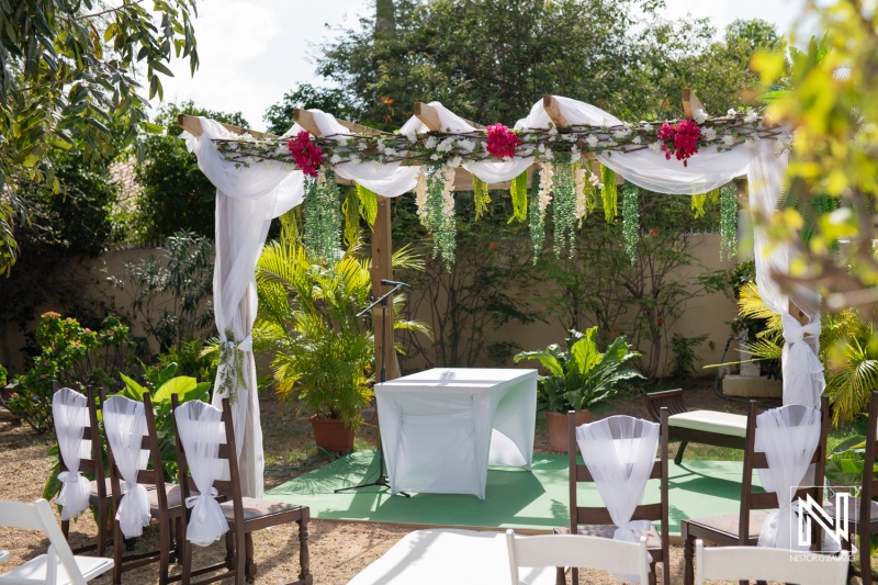 Beautiful wedding setup in Curacao featuring a floral arch and seating arrangement in a lush garden setting