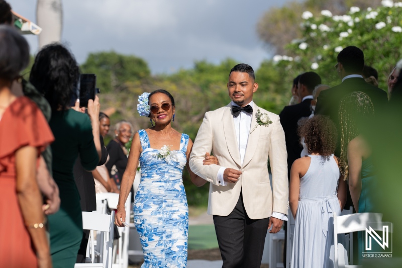 Elegant wedding procession in Curacao showcases vibrant attire and joyful atmosphere on a sunny day
