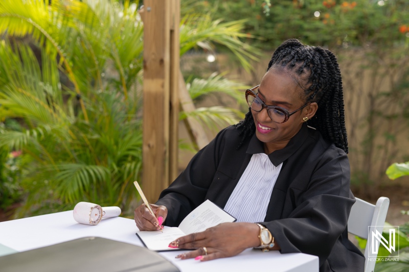 Celebrating love at a wedding in Curacao with a dedicated officiant writing vows under tropical greenery