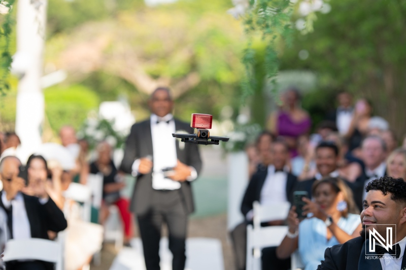 Guests gather in Curacao to celebrate a beautiful wedding ceremony surrounded by lush greenery and elegant decor at a picturesque venue