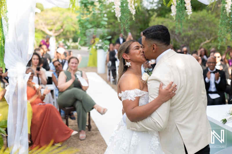 Couple shares heartfelt kiss during wedding ceremony in Curacao surrounded by friends and family
