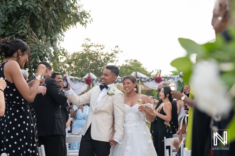 Joyful wedding celebration in Curacao featuring a couple surrounded by guests enjoying the moment under a clear sky
