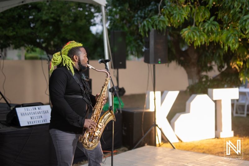 Saxophonist performing live during a vibrant wedding celebration in Curacao with beautiful outdoor decor at sunset