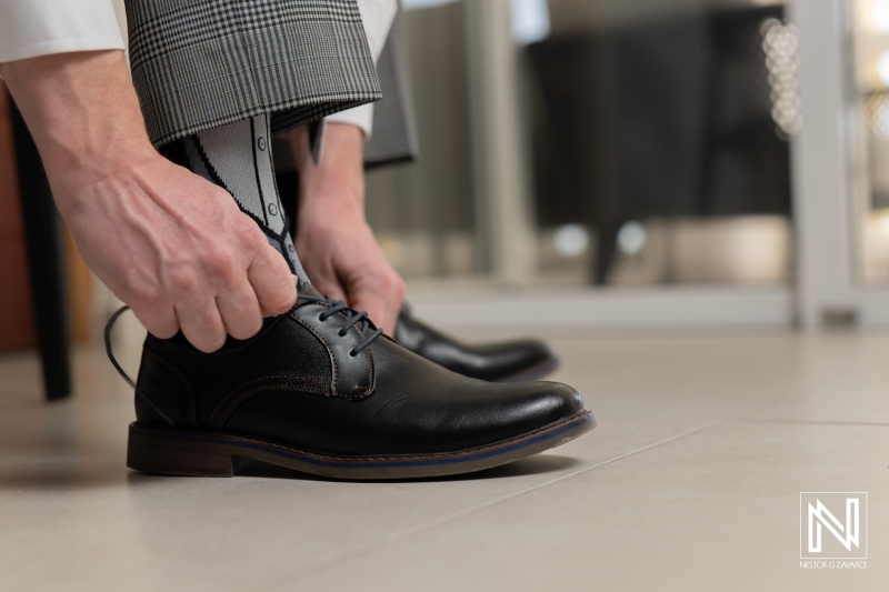 Putting on shoes for a wedding ceremony at Avila Beach Hotel in Curacao with elegant attire and thoughtful preparation