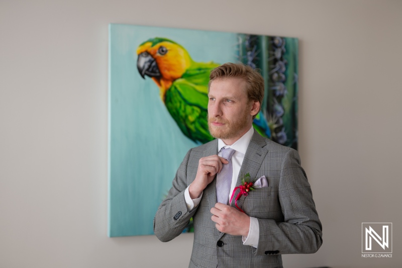 Groom prepares for wedding ceremony at Avila Beach Hotel in Curacao surrounded by vibrant tropical art