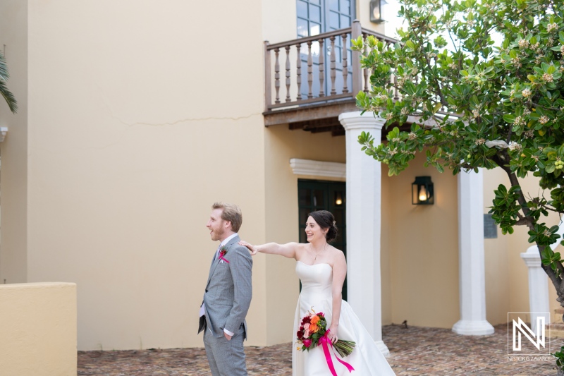 Wedding couple at Avila Beach Hotel in Curacao share a special moment before their ceremony surrounded by beautiful architecture and lush greenery