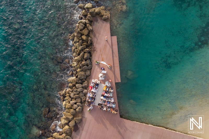 Couple exchanges vows at beachfront wedding ceremony in Curacao near Avila Beach Hotel surrounded by guests and turquoise waters