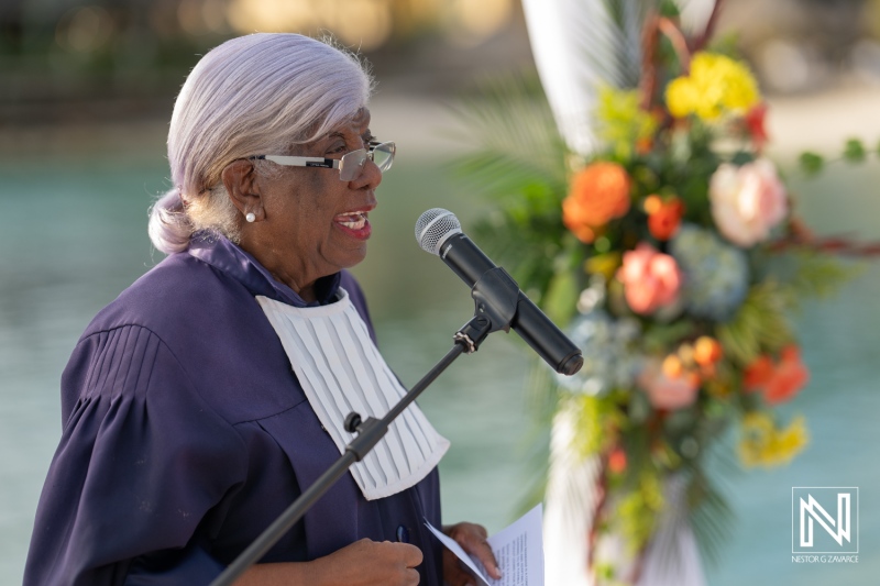 Wedding officiant delivering heartfelt vows at an elegant ceremony by the beach in Curacao at Avila Beach Hotel during sunset