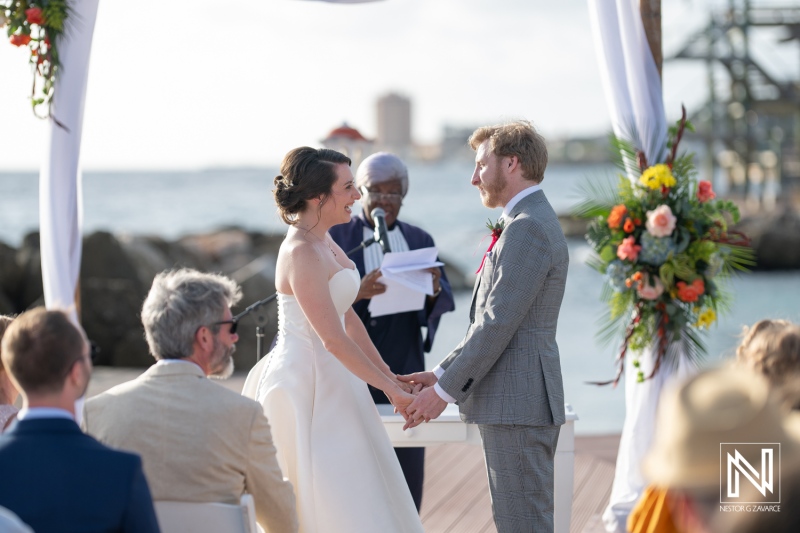 Couple exchanges vows during a beautiful wedding ceremony at Avila Beach Hotel in Curacao under a clear sky