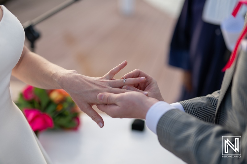 Couple exchanges wedding rings during a beautiful ceremony at Avila Beach Hotel in Curacao on a sunny day