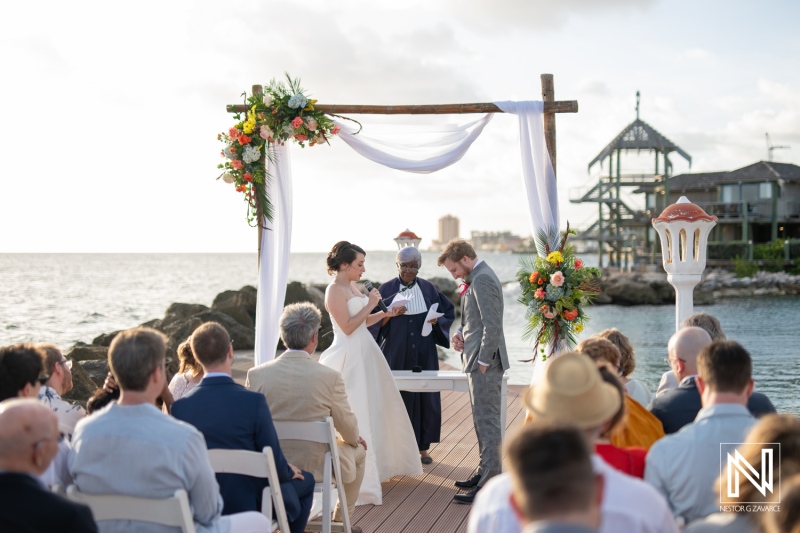 Couple exchanging vows during a romantic wedding ceremony at Avila Beach Hotel in Curacao with ocean backdrop