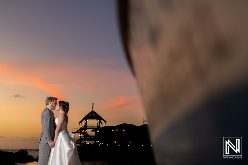 Couple celebrates their wedding at Avila Beach Hotel in Curacao during sunset with a romantic backdrop and scenic views