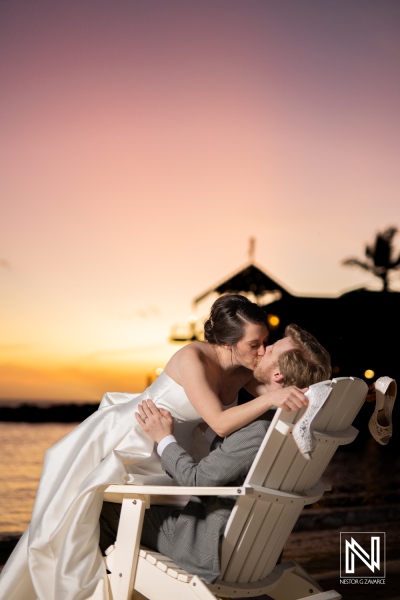 Couple enjoys a romantic kiss on the beach at Avila Beach Hotel during sunset in Curacao