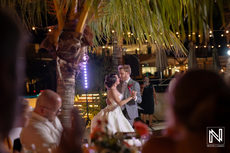 Couple celebrates their wedding with a first dance at Avila Beach Hotel in Curacao surrounded by friends and family at night