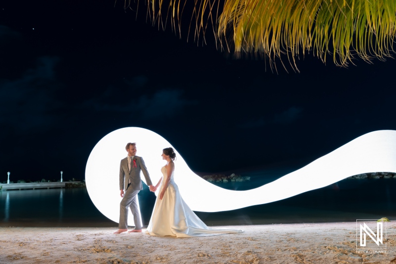 Couple celebrates their wedding at Avila Beach Hotel in Curacao with a beautiful night backdrop and artistic lighting