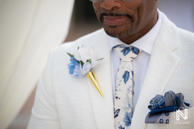 Wedding celebration at Avila Beach Hotel with a groom in a suit with floral details and stylish accessories