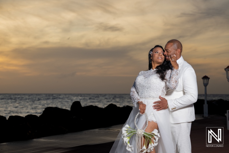 Couple celebrates their wedding at Avila Beach Hotel in Curacao with ocean view at sunset
