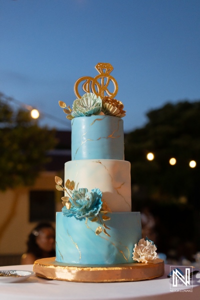 Wedding cake at Avila Beach Hotel during a celebration in Curacao with guests enjoying the evening outdoors