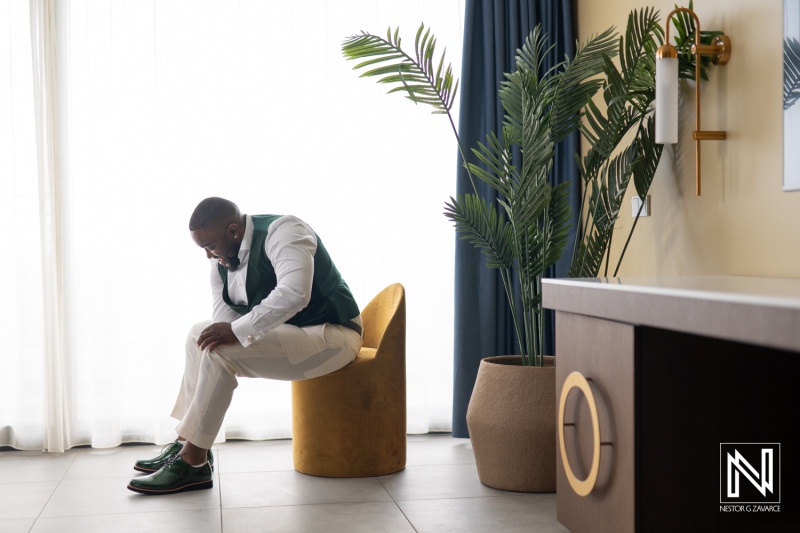 Groom preparing for wedding ceremony at Mangrove Beach Corendon in Curacao during a bright sunny day