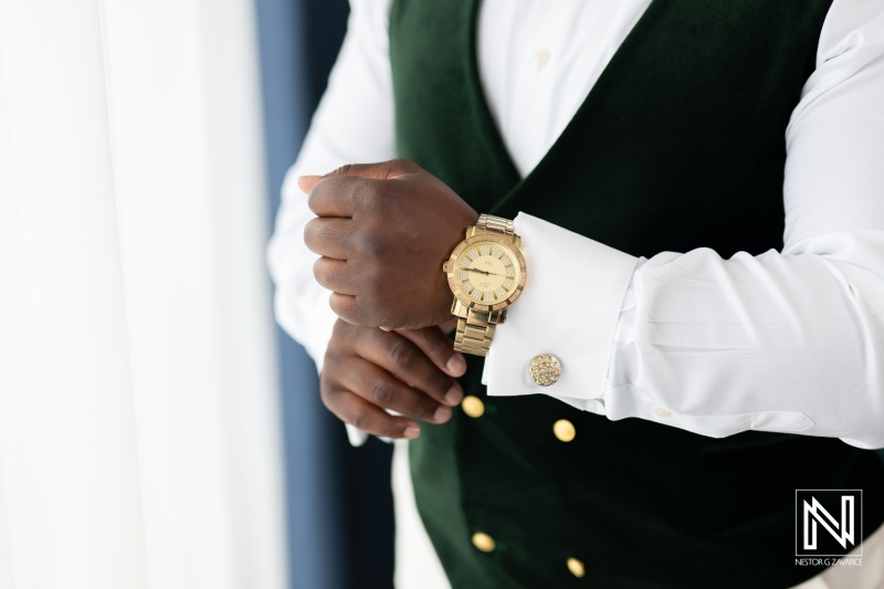Groom adjusting his watch before the wedding ceremony at Mangrove Beach Corendon in Curacao in a beautiful indoor setting