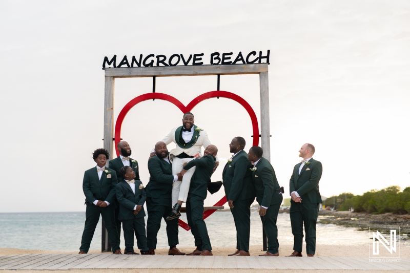 Groom celebrated by friends during wedding festivities at Mangrove Beach in Curacao