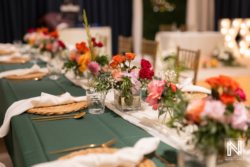 Beautiful floral arrangements decorate the elegant wedding table at Mangrove Beach Corendon in Curacao, creating a vibrant atmosphere for the special event