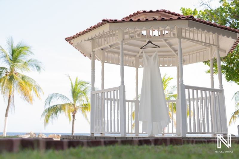 Beautiful wedding dress displayed in a gazebo at Sunscape Curacao Resort surrounded by palm trees and ocean views