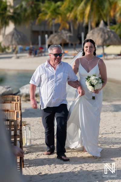 Wedding ceremony at Sunscape Curacao Resort featuring the bride and her father walking along the beach