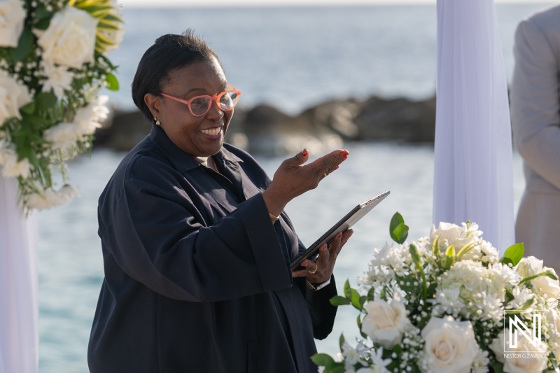 Ceremony officiant joyfully delivers vows during an elegant wedding at Sunscape Curacao Resort on a beautiful sunny day