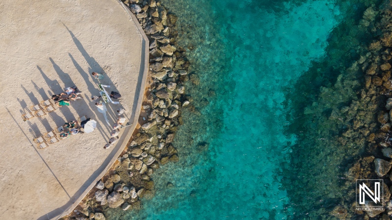 Wedding ceremony at Sunscape Curacao Resort overlooking the clear blue waters surrounded by rocks