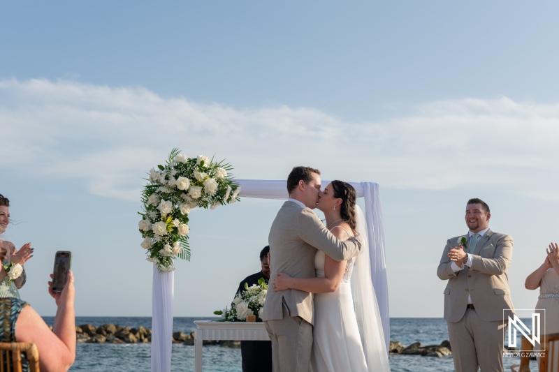 Couple shares a romantic kiss during their wedding ceremony at Sunscape Curacao Resort overlooking the beautiful Caribbean Sea