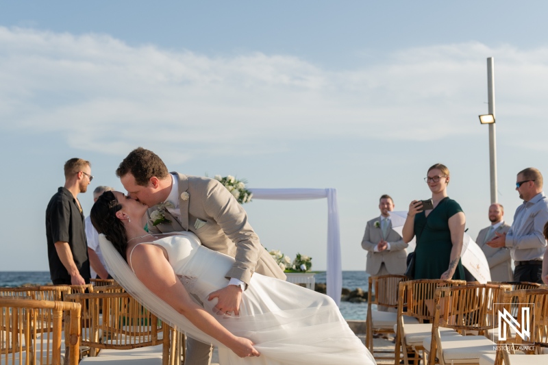 Wedding couple shares a romantic kiss during sunset ceremony at Sunscape Curacao Resort