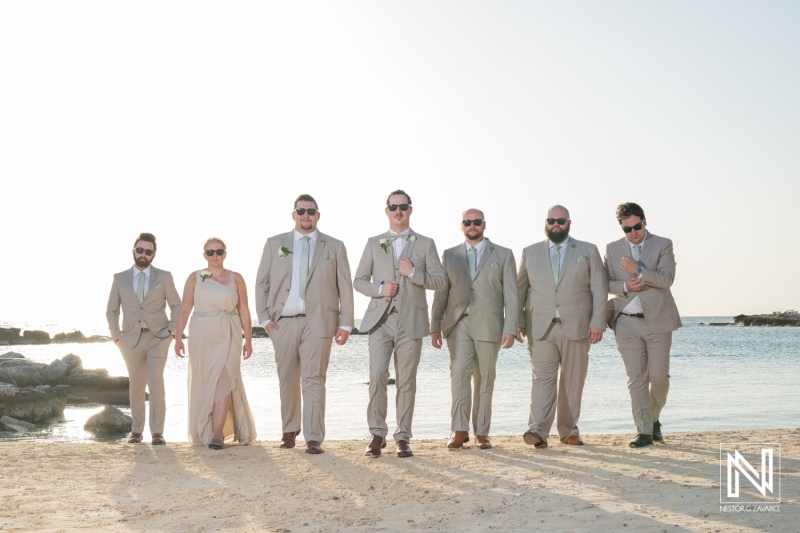 Groom and groomsmen in light suits strolling along the beach at Sunscape Curacao Resort during a wedding celebration under the warm Caribbean sun