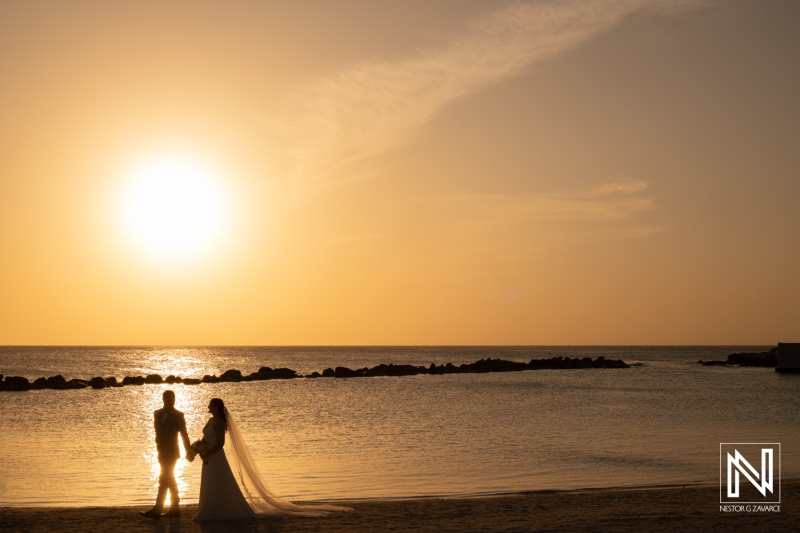 Beautiful wedding couple enjoying sunset at Sunscape Curacao Resort on a romantic beach